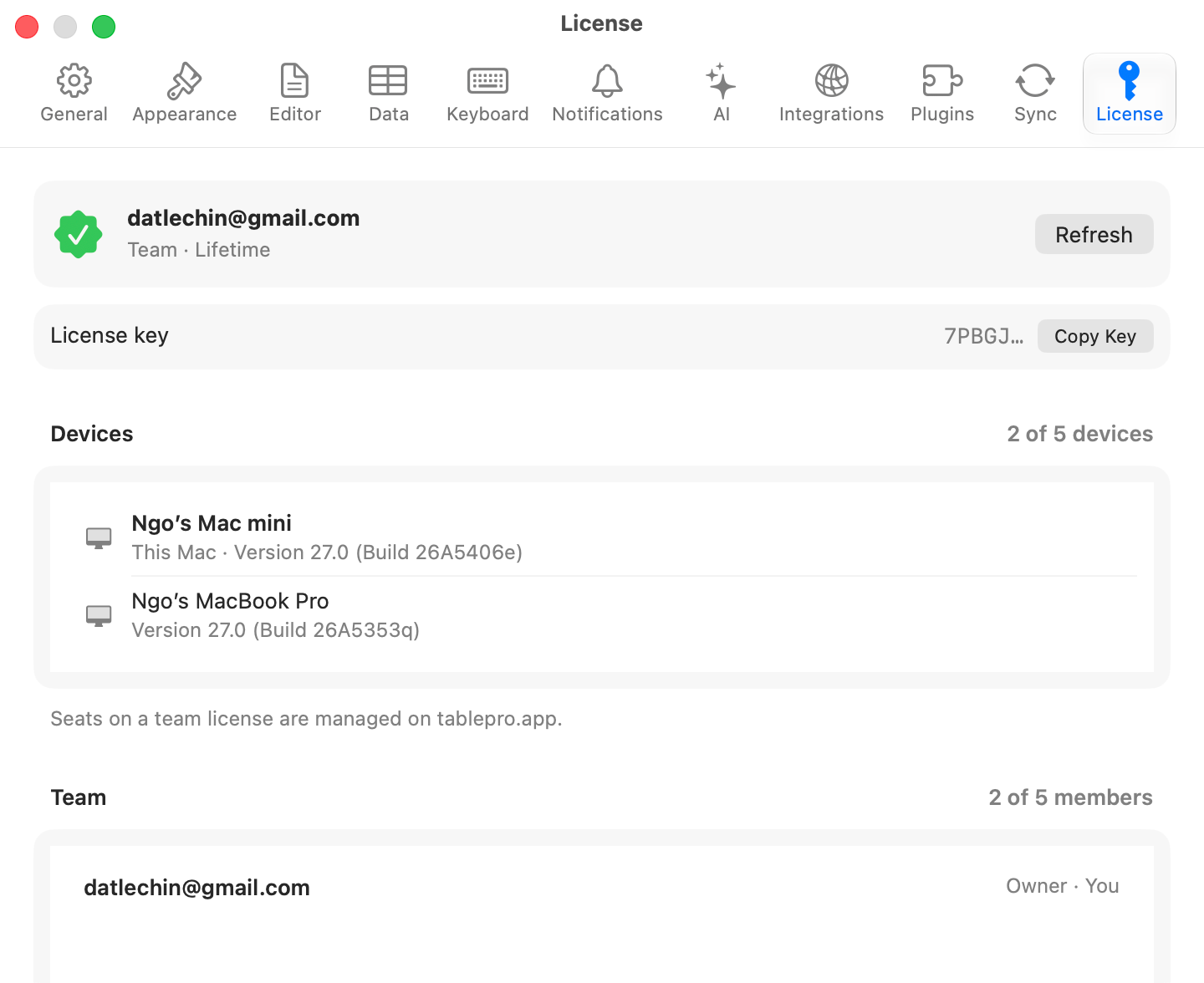 TablePro Settings window on the License pane showing a masked license key with a Copy Key button, a device list naming each activated Mac with its last use and macOS version and a Release button beside the others, and a team section listing members with seats used against seats bought